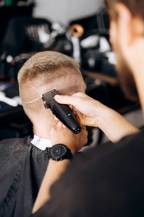 Barber trimming hair with clipper